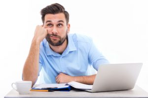 man looking bored during virtual meeting