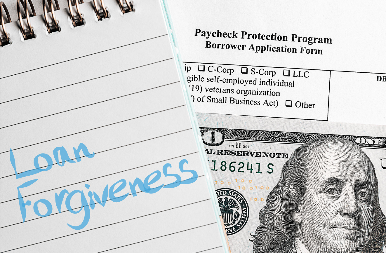 Photo with a Paycheck Protection Program application layered by a $100 bill and a note pad with Loan Forgiveness written in blue text.